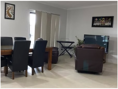 Dining and living area with a wooden table, chairs and television